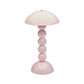 The Addison Ross Bobbin LED Cordless Lamp features a glossy light pink bobbin-shaped base of stacked spheres, a round dome shade, and offers portable lighting with adjustable levels for versatile ambiance.