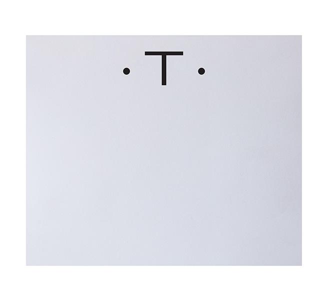 The Black Ink Black Initial Large Notepad features a white rectangular background with two small black dots and a bold black "T," creating a minimalistic face reminiscent of fine stationery.