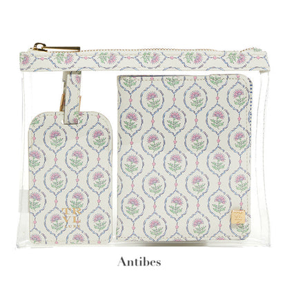 A transparent pouch holds the LUXE Saffiano Travel Set by TRVL Design—a matching floral-patterned luggage tag and passport cover, labeled "Antibes" below.
