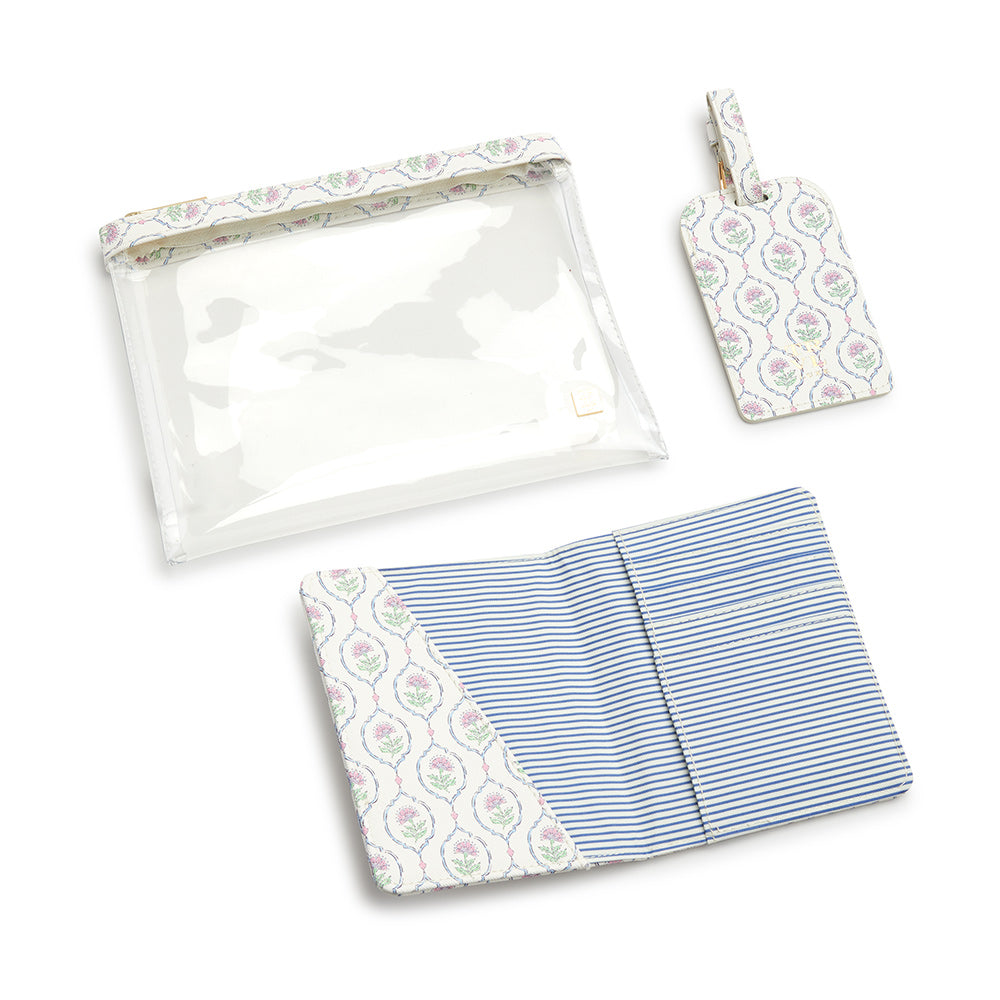 Clear zippered pouch, patterned luggage tag, and striped passport cover from the LUXE Saffiano Travel Set by TRVL Design with matching floral print accents, displayed on a white background.
