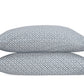 Two rectangular pillows from the Laksha Bedding Collection by Matouk, featuring a blue and white geometric diamond pattern inspired by Indian block printing, stacked on top of each other against a white background.