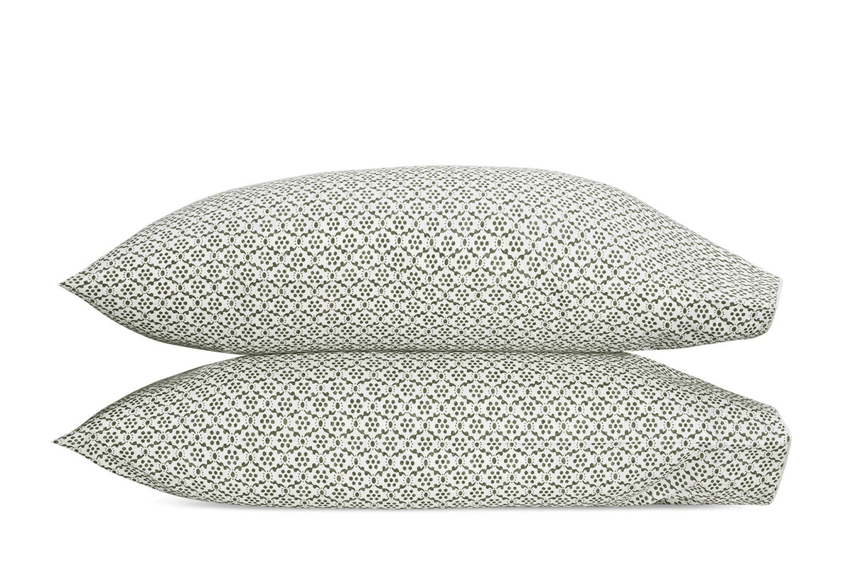 Two stacked pillows from the Laksha Bedding Collection by Matouk, featuring a small black geometric pattern on crisp white Luca percale pillowcases, inspired by classic Indian block printing.