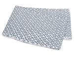 Folded white fabric from the Matouk Laksha Bedding Collection, featuring a repeating blue dot and line pattern inspired by Indian block printing, displayed on a white background.