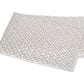 A folded white blanket from the Laksha Bedding Collection by Matouk, featuring a beige dot and line pattern inspired by Indian block printing techniques, displayed on a plain white background.