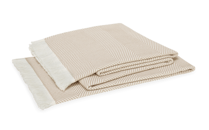 The Leo Throw by Matouk is an oversized beige and white herringbone blanket with fringed edges, crafted from 100% cotton. Stylish and contemporary, it's perfect for any space and is shown here against a white background.