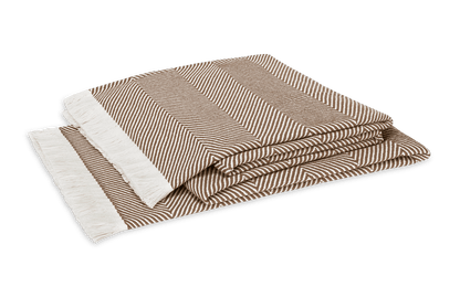 The Matouk Leo Throw, crafted from 100% cotton in a brown and white herringbone design with a white fringe, is shown folded against a white background.
