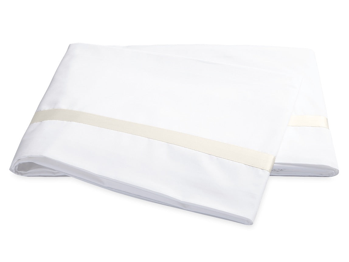 Two folded white bed sheets from the Lowell Bedding Collection by Matouk, featuring a subtle beige stripe near the edge. Expertly crafted from Egyptian cotton percale for exceptional softness and breathability, these luxurious sheets are displayed on a plain white background—perfect for elevating your home bedding experience.