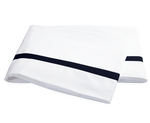 Two folded white pillowcases from the Matouk Lowell Bedding Collection in Navy, crafted from 600 thread count Egyptian cotton percale with a single navy stripe near the edge, are displayed on a plain background.