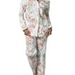 A person stands barefoot against a white background wearing the Matouk Luca Pajama Set, crafted from soft cotton percale and featuring a nature-inspired print of coral and sea plants.