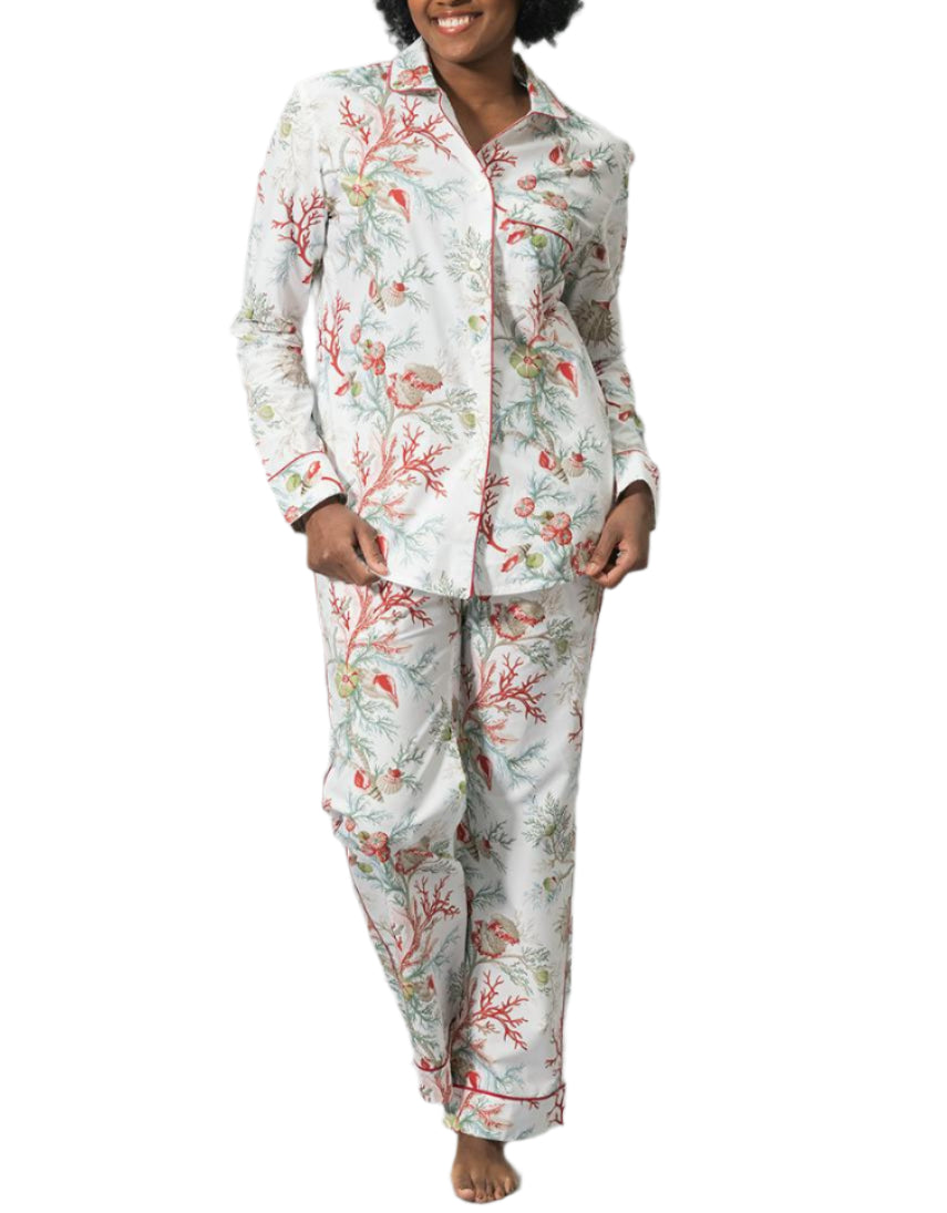 A person stands barefoot against a white background wearing the Matouk Luca Pajama Set, crafted from soft cotton percale and featuring a nature-inspired print of coral and sea plants.