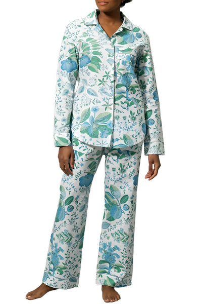 A person wearing a Matouk Luca pajama set made of OEKO-TEX Standard 100 certified Egyptian cotton, in shades of blue and green, standing against a white background.