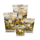 Baobab Collection Far West Candles in four sizes featuring an aromatic woody fragrance, decorated with a colorful mountain landscape, horses, buildings, and people, finished with a gold rim.