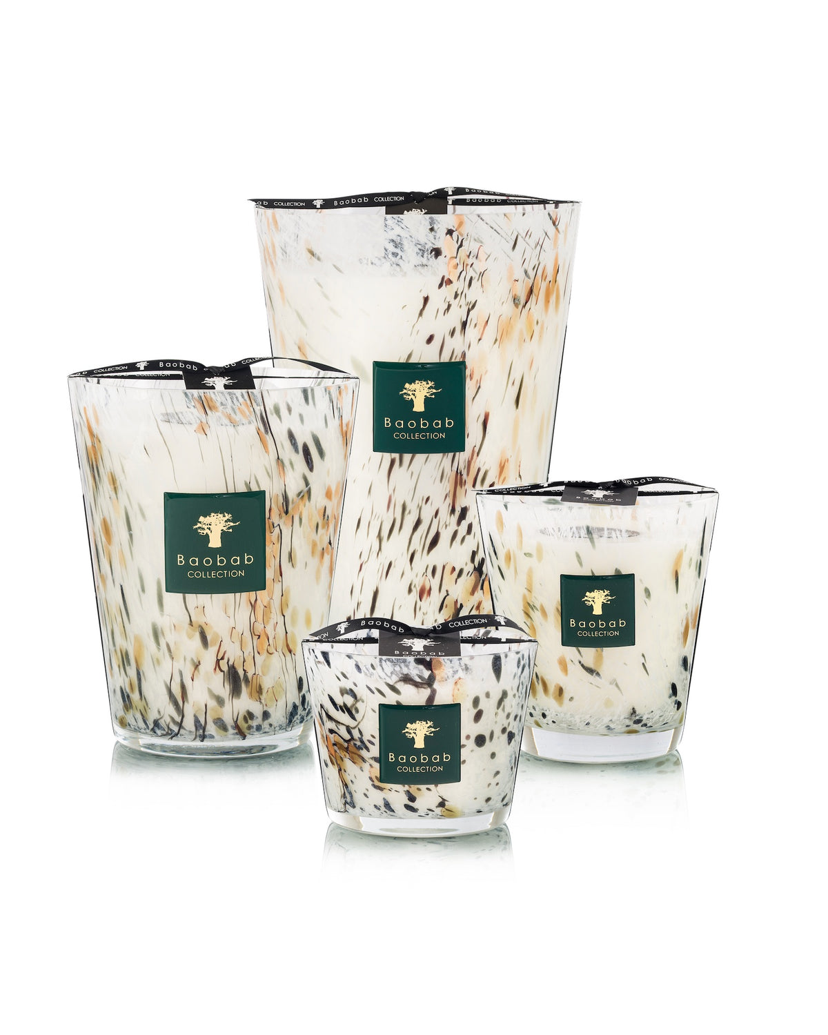 Four Baobab Collection Halona White World candles in various sizes with a speckled white, black, and amber pattern, each featuring a green square label with a tree logo and text.