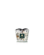 A hand-blown Baobab Collection Halona White World Candle with a black and white speckled pattern, dark green label with gold tree logo, and a black ribbon rim.