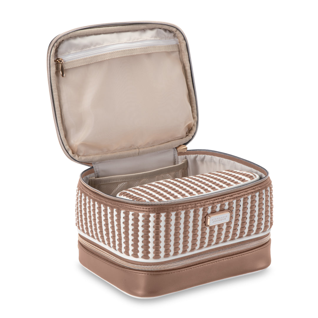 From the Marbella Mocha Travel Collection by Stephanie Johnson, this beige and brown travel case features a textured exterior. When open, it reveals a zippered mesh pocket in the lid and an inner removable cosmetic pouch with a stylish striped pattern.
