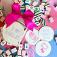 Haute Papier Mahjong Coasters: a chic hostess gift featuring round, letterpressed designs inspired by mahjong. Tied with a pink ribbon and crafted from recycled chipboard for eco-friendliness.