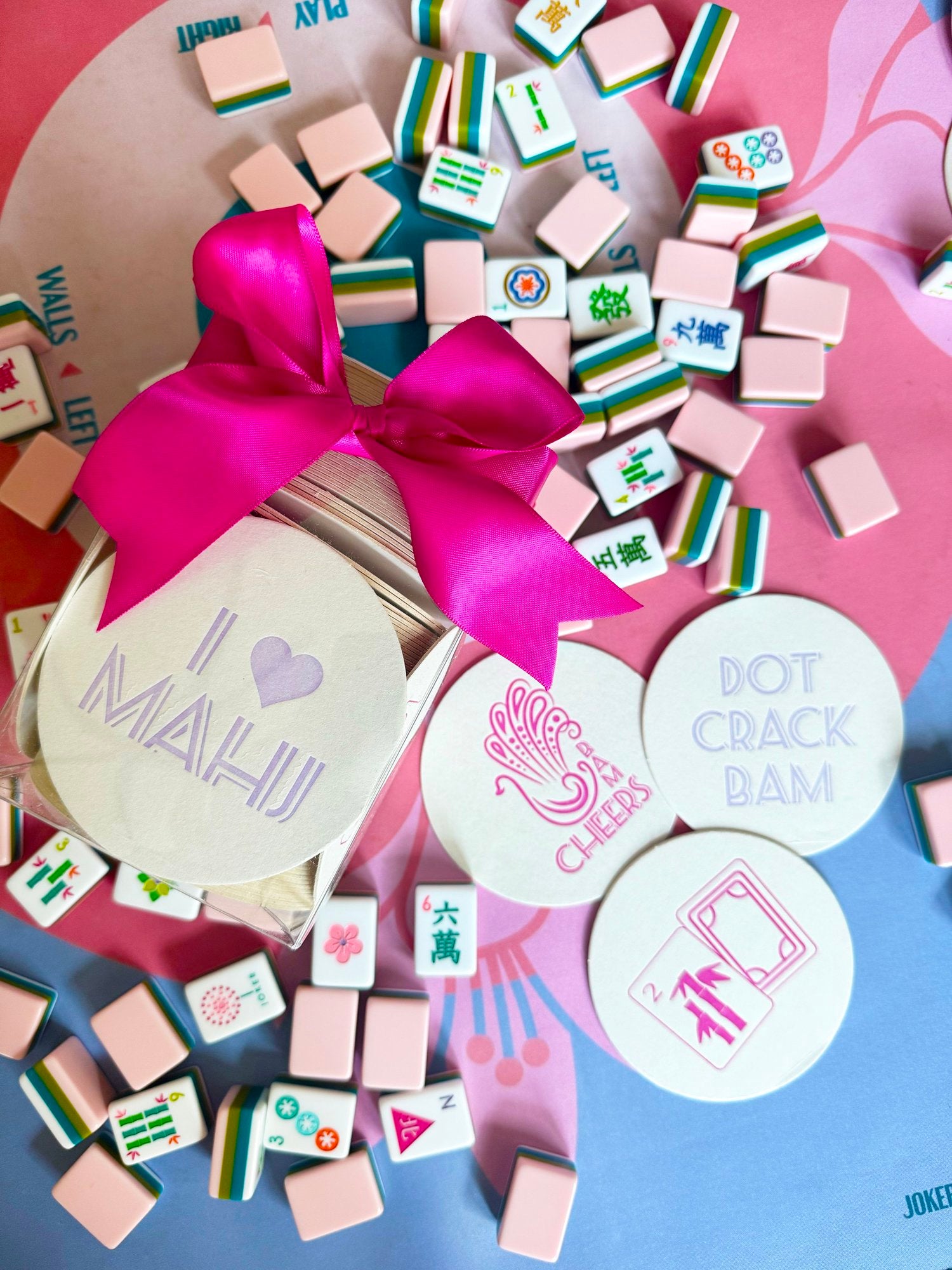 Haute Papier Mahjong Coasters: a chic hostess gift featuring round, letterpressed designs inspired by mahjong. Tied with a pink ribbon and crafted from recycled chipboard for eco-friendliness.