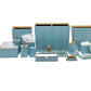 The Manchester Bath Collection by Pigeon & Poodle features matching light blue bathroom accessories with a subtle shagreen texture, including waste bins, tissue boxes, trays, soap dispensers, and containers.