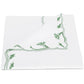 Beautifully folded white napkin from the Marcella Bedding Collection by Matouk, featuring green scalloped floral embroidery along the edges and partially flipped to reveal the elegant design on both sides.