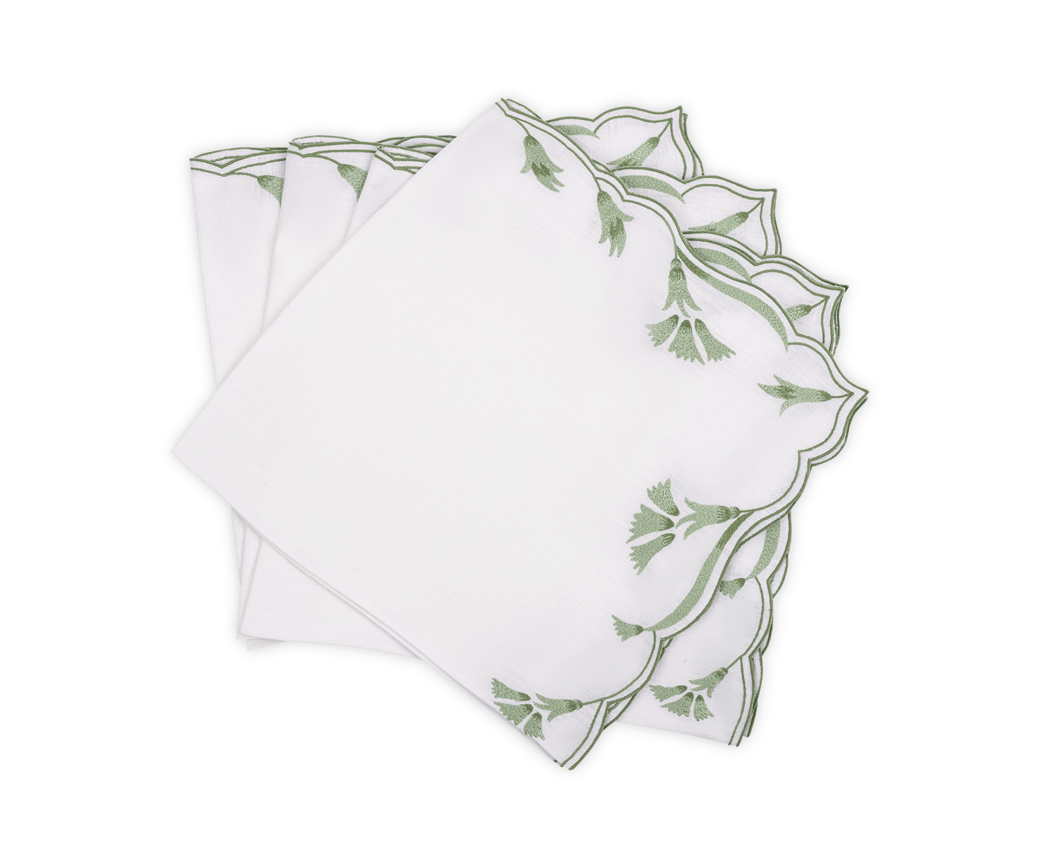 A set of four Marcella Napkins by Matouk, featuring white fabric with green embroidered leaf motifs and scalloped edges, displayed fanned out on a white background.