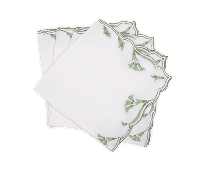 A set of four Marcella Napkins by Matouk, featuring white fabric with green embroidered leaf motifs and scalloped edges, displayed fanned out on a white background.