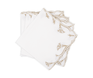The Marcella Napkin Set by Matouk features three white cloth napkins with scalloped edges and beige embroidered leaf patterns, neatly stacked on a white background.