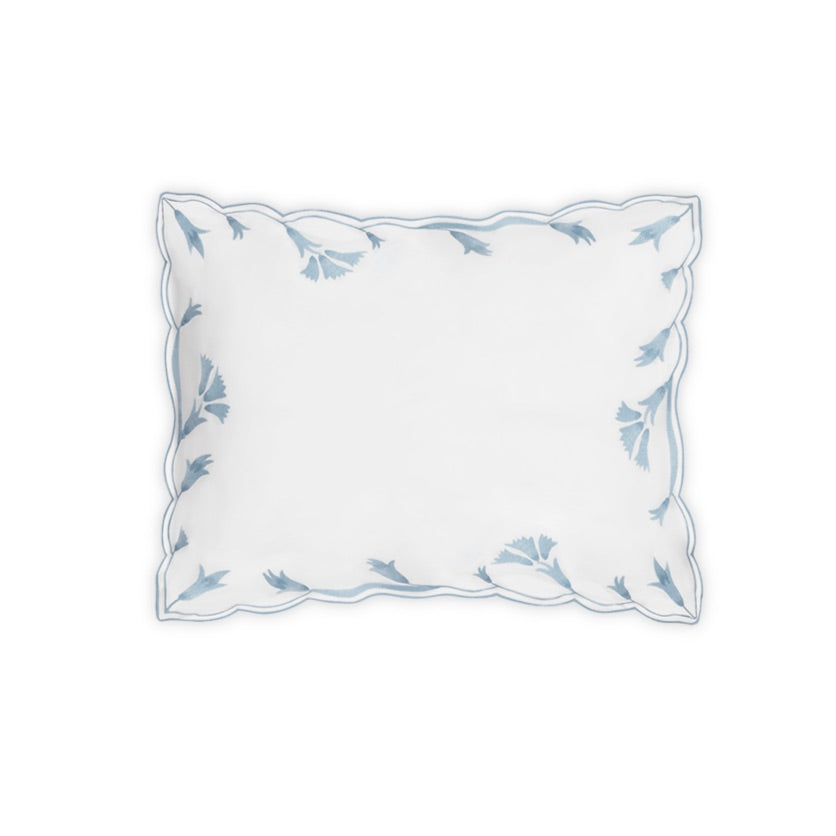 The Marcella Bedding Collection by Matouk features a white rectangular pillow with scalloped edges and delicate light blue leaf embroidery framing the border, crafted from luxuriously smooth Nocturne sateen and shown on a plain white background.