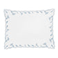 A rectangular white placemat from the Marcella Bedding Collection by Matouk, featuring scalloped edges and a border of light blue leaf patterns, inspired by the collection’s embroidered bedding and delicate florals.