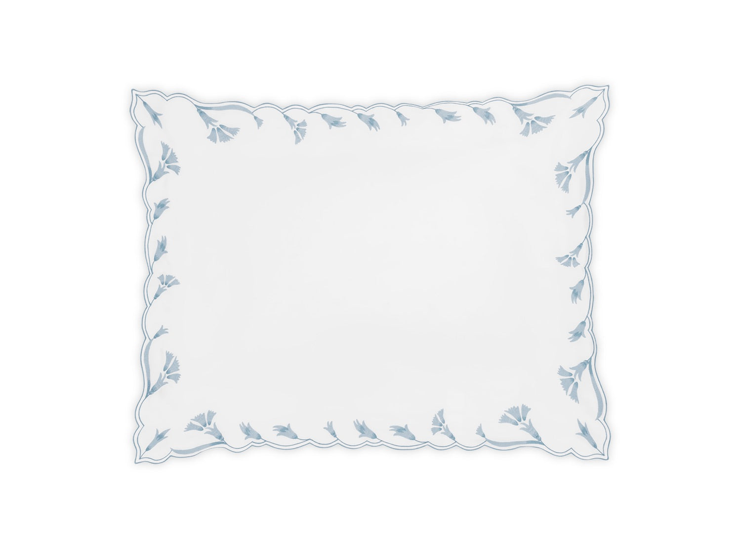 A rectangular white placemat from the Marcella Bedding Collection by Matouk, featuring scalloped edges and a border of light blue leaf patterns, inspired by the collection’s embroidered bedding and delicate florals.