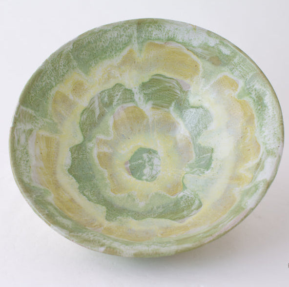 The Geode Bowl Collection by Paul Schneider Ceramics features a ceramic bowl with a green and yellow marbled swirl, seen from above on a white background—ideal for adding unique style to your home decor.