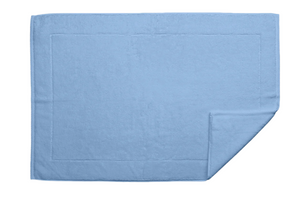 The Matouk Milagro Bath Collection in Azure features a blue rectangular towel made from OEKO-TEX certified cotton. Displayed on a white background with a folded corner, this towel by Matouk is known for its exceptional absorbency, making it an ideal bath essential.