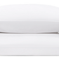 Two white pillows from the Matouk Mirasol Bedding Collection in Grass, featuring green wave-like trim on one edge, highlight the luxurious softness of Egyptian cotton percale against a plain background.