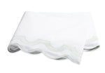 Showcasing the Mirasol Bedding Collection by Matouk, this folded white sheet features elegant scalloped edges and delicate light green trim, expertly crafted from luxurious Egyptian cotton percale with a 600 thread count, displayed against a plain white background.