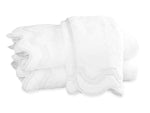 Neatly folded white towels from the Matouk Mirasol Bath Collection, crafted in premium cotton terry with elegant scalloped edges—timeless style inspired by the classic Matouk aesthetic.