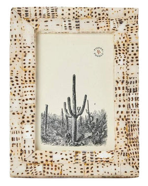 The Mombasa Frame Collection by Pigeon & Poodle features a rectangular photo frame in smooth resin with a beige and brown dotted pattern, shown displaying a black and white illustration of cacti and a small human figure.