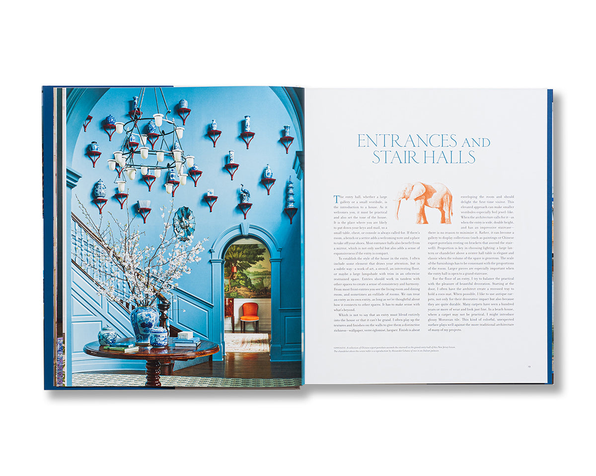 An open book, "More Rooms" by Vendome, shows a blue-painted entrance hall with wall sconces and a chandelier on the left; the right page features text titled "Entrances and Stair Halls.