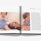 An open copy of "Mother and Child" by Assouline reveals an evocative portrait by Claiborne Swanson Frank of a woman with two children on a beach, alongside text—a striking glimpse into modern motherhood.