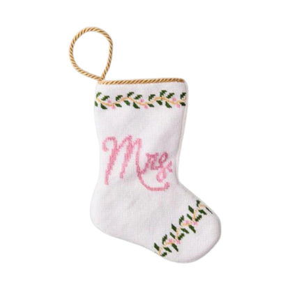 The Mrs. Needle Point Stocking by Bauble Stockings features white fabric, pink "Mrs." lettering, hand-stitched green and pink trim, and a gold loop—perfect as a wedding keepsake or charming Mrs. Bauble Stocking.