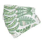 The Addison Ross Palm Beach Napkin Set features folded white linen napkins with a green and pink tropical leaf design, adding a touch of luxury to your table.