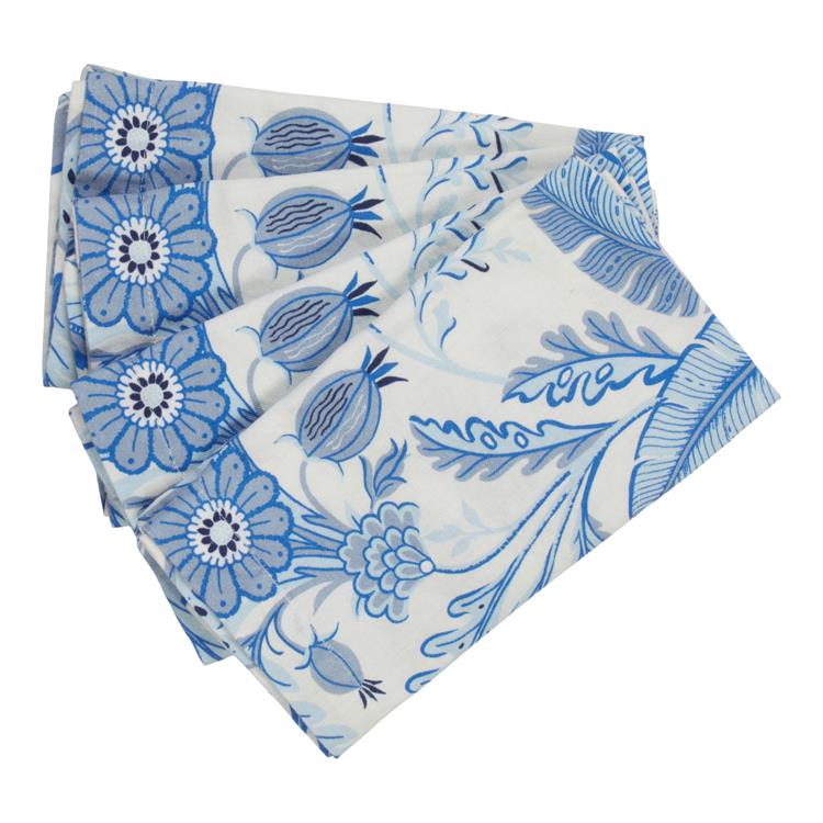 The Addison Ross Palm Beach Napkin Set features folded white luxury linen napkins with a blue floral and leaf design, adding botanical elegance to your table.