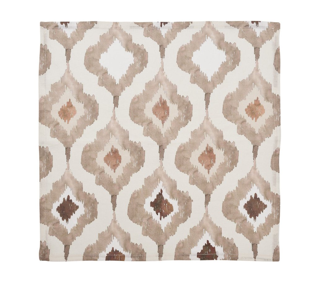 The Watercolor Ikat Napkin Set by Kim Seybert features a hand-painted beige, brown, and cream Ikat pattern on white fabric, inspired by linen watercolor designs.