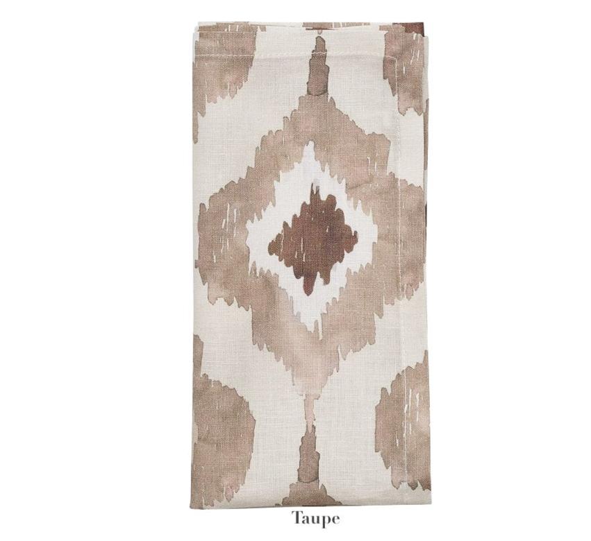 The Kim Seybert Watercolor Ikat Napkin Set features folded beige napkins with a taupe and beige geometric abstract pattern, inspired by hand-painted Ikat designs and labeled "Taupe" at the bottom.