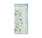 The Mira Napkin Set by Kim Seybert features folded rectangular linen napkins with a hand-painted blue, green, and white floral and paisley pattern accented with a striped border.