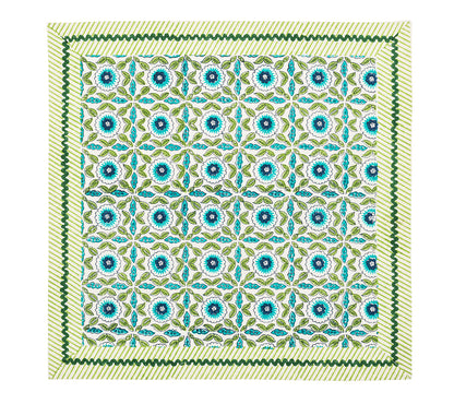 The Majorelle Napkin Set by Kim Seybert features a floral and geometric pattern in blue, green, and yellow, accented with diagonal yellow stripes and a green zigzag border, inspired by handcrafted napkins and Indian block printing.