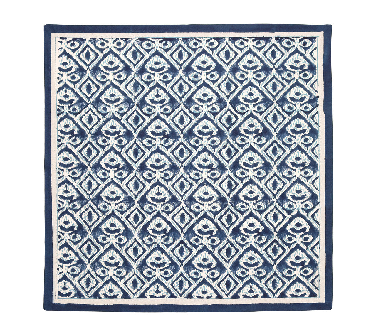 The Alfresco Napkin Set by Kim Seybert features a dark blue and white geometric pattern inspired by block printing, with repeating diamond shapes, stylized floral designs, and a solid blue border.
