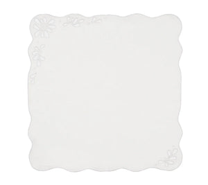 The Bloom White Napkin Set by Kim Seybert features square white linen napkins with scalloped edges, subtle floral patterns in two corners, and delicate eyelet embroidery for a touch of vintage charm.