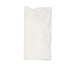 The Bloom White Napkin Set by Kim Seybert features folded white linen napkins with scalloped edges and floral eyelet embroidery, bringing vintage charm to any table setting.