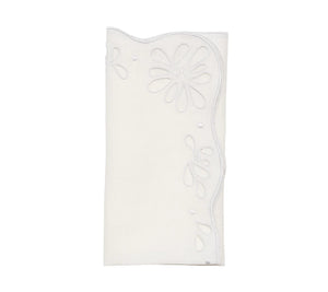 The Bloom White Napkin Set by Kim Seybert features folded white linen napkins with scalloped edges and floral eyelet embroidery, bringing vintage charm to any table setting.