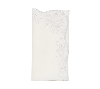 The Bloom White Napkin Set by Kim Seybert features folded white linen napkins with scalloped edges and floral eyelet embroidery, bringing vintage charm to any table setting.