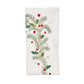 The Christmas Carol Table Linen Collection by Kim Seybert features a white embroidered linen napkin adorned with green pine branches, holly leaves, and red and gold berries—ideal for festive holiday table settings.